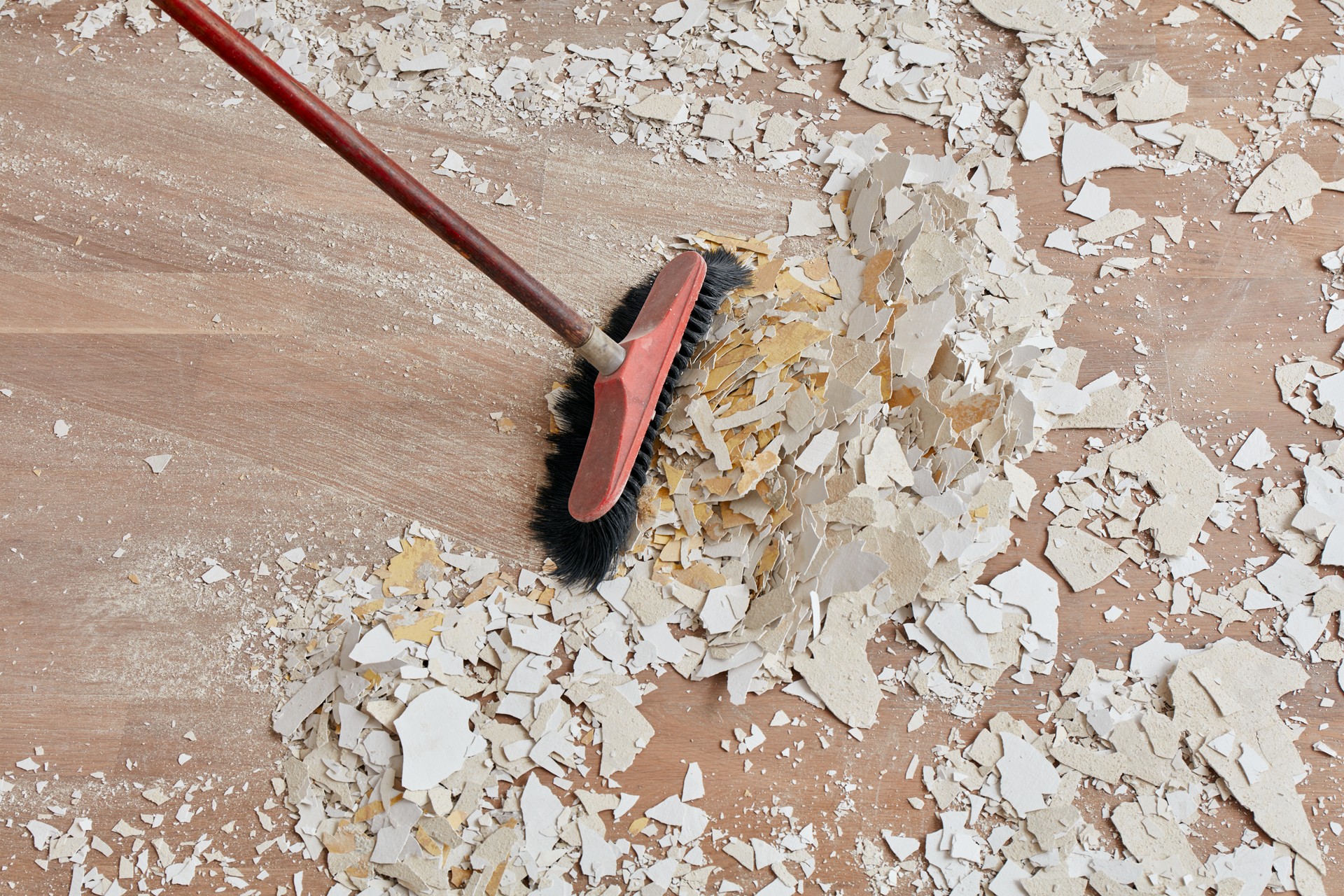 Builder sweeping the floor after renovation